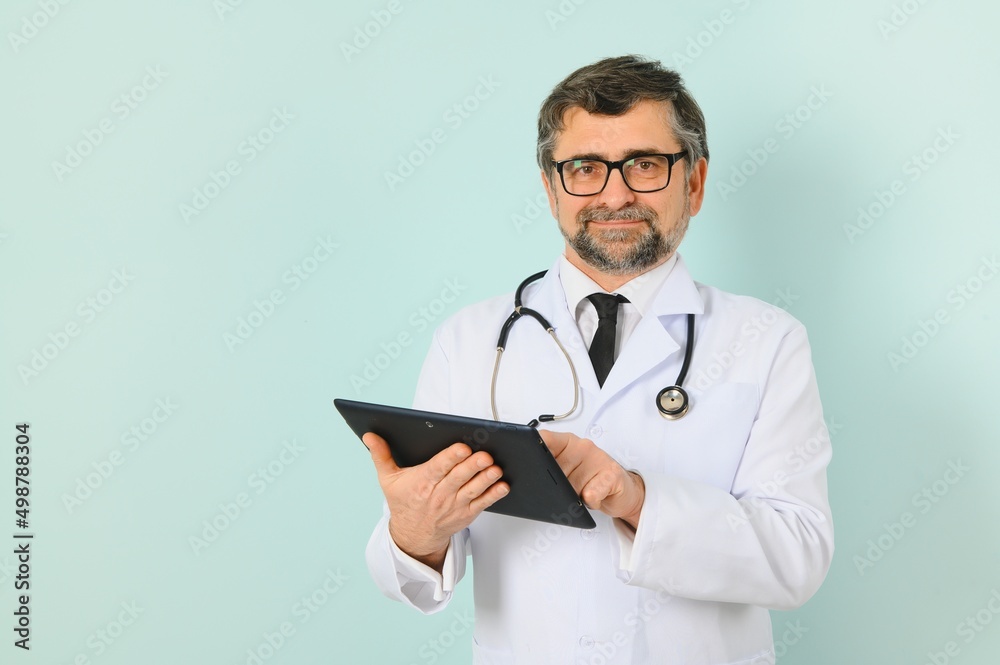Smiling medical senior doctor with a stethoscope. On a blue background. The concept of humanity's victory over disease Smiling medical senior doctor with a stethoscope. On a blue background. The concept of humanity's victory over disease