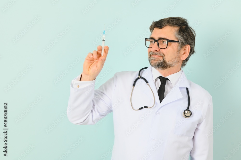 Vaccination against coronavirus. Testing COVID-19 vaccines. A male doctor fills a syringe the with a COVID-19 vaccine on a blue background. Doctor's hands hold a syringe close-up Vaccination against coronavirus. Testing COVID-19 vaccines. A male doctor fills a syringe the with a COVID-19 vaccine on a blue background. Doctor's hands hold a syringe close-up