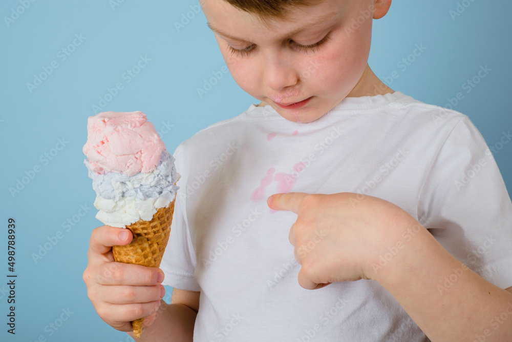 Close up dirty stains of ice cream on a children's t-shirt on a blue background. daily life stain and cleaning concept 