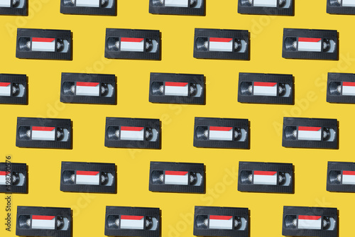 VHS video cassette, Old black videotape pattern on a yellow background, Outdated technology background.