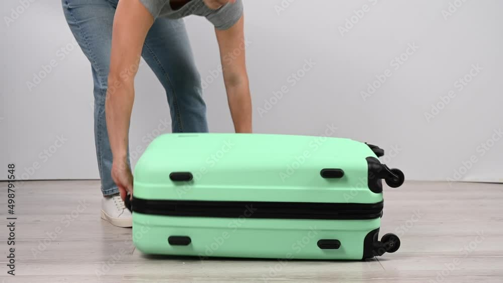 The woman puts her luggage bag on the floor and jumps from above. The