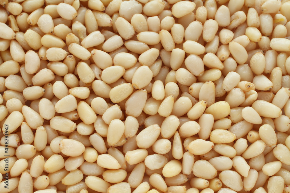 A pile of raw shelled pine nuts arranged randomly. View from above. Closeup A pile of raw shelled pine nuts arranged randomly. View from above. Closeup