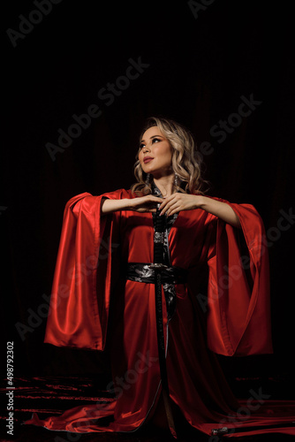 a girl in a red kimono with a sword