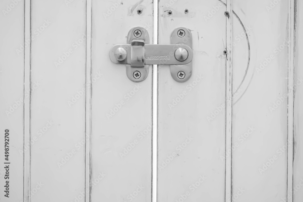 Black and white tone closeup stainless steel padlock with wooden door Black and white tone closeup stainless steel padlock with wooden door