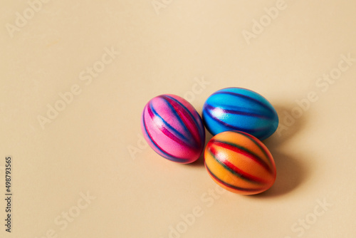 Colorful Easter eggs with on a solid beige background. Preparation for holiday.