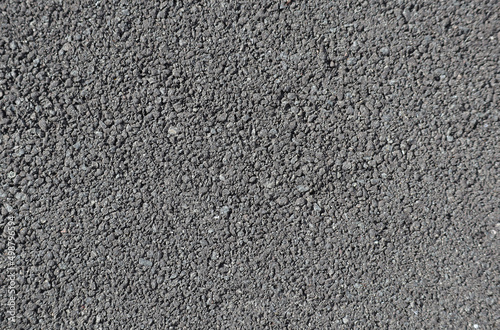 Coarse gray asphalt in daylight, road pavement