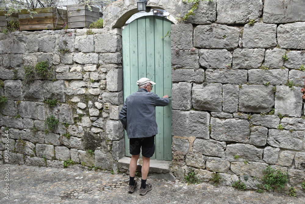 Vieil homme devant une porte verte Vieil homme devant une porte verte