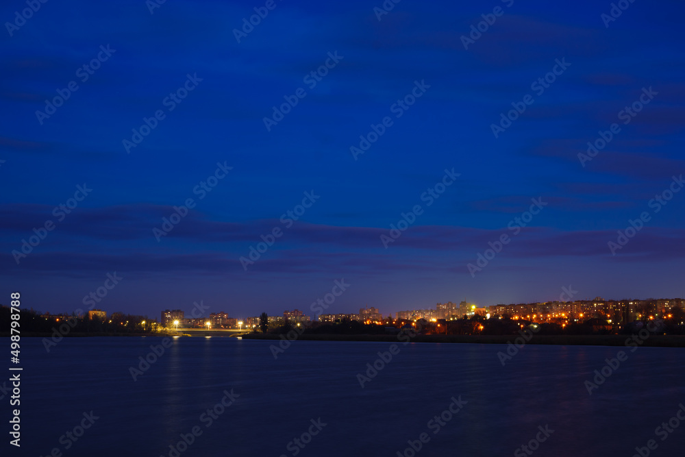 A view of the city at night from a river or lake. Night scenery of a big city