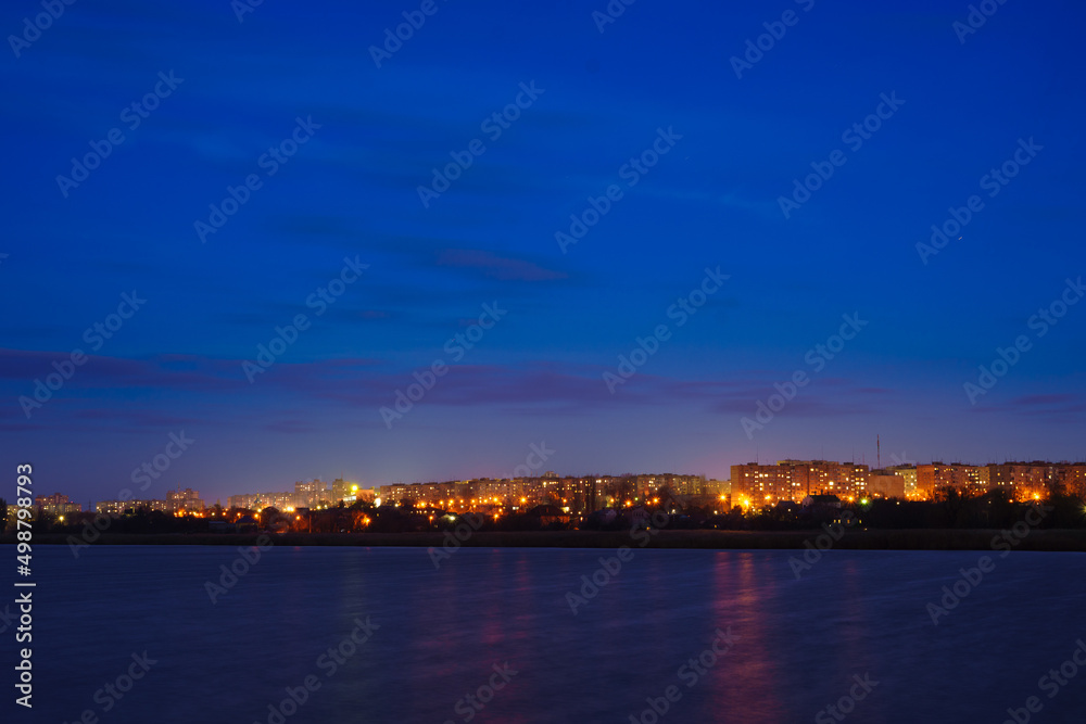 A view of the city at night from a river or lake. Night scenery of a big city