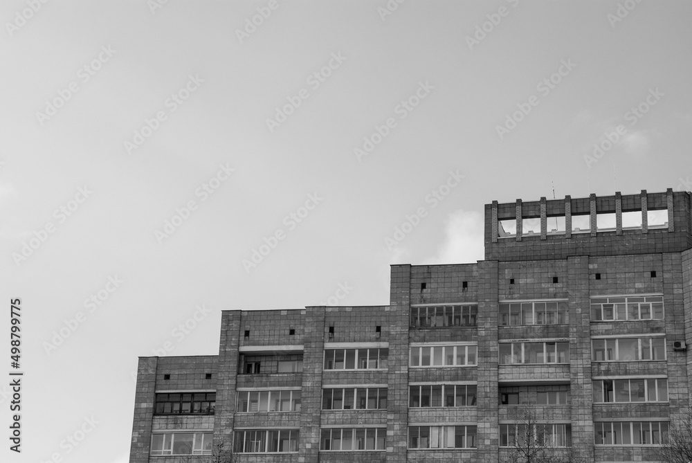 Skyscraper in a residential area against the sky. Russian architecture in the North. Black and white