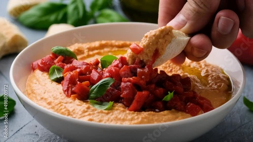 Eating roasted red pepper hummus with pita bread.