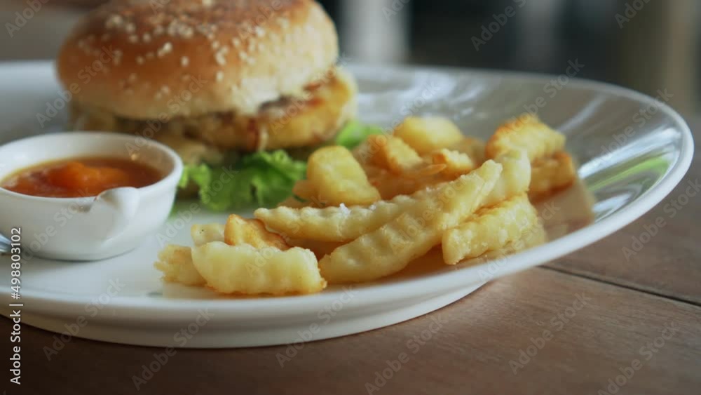 Vegetarian burger with red sauce and fries standing on a white plate Vegetarian burger with red sauce and fries standing on a white plate