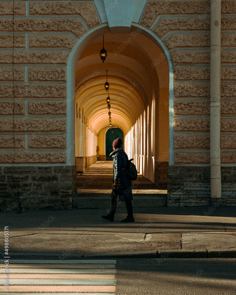 woman in the arch street photo walking light sun shadows 