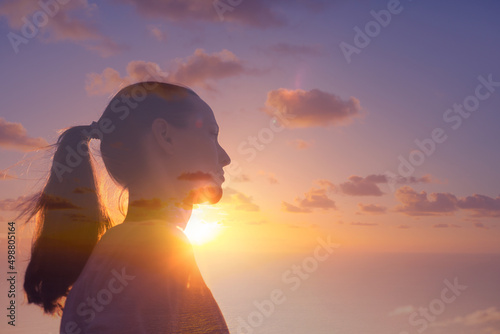 Thoughtful woman looking out to the sunrise. New day, new beginning concept. 