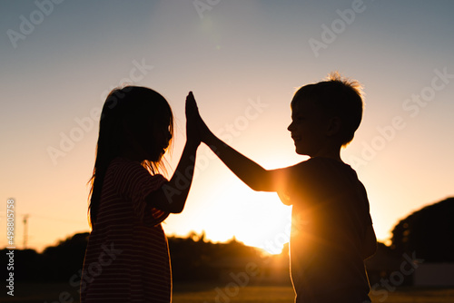 Boy and girl working as a team giving high five 