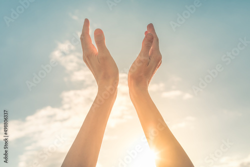 Worshiping hands up to the sun at dawn 