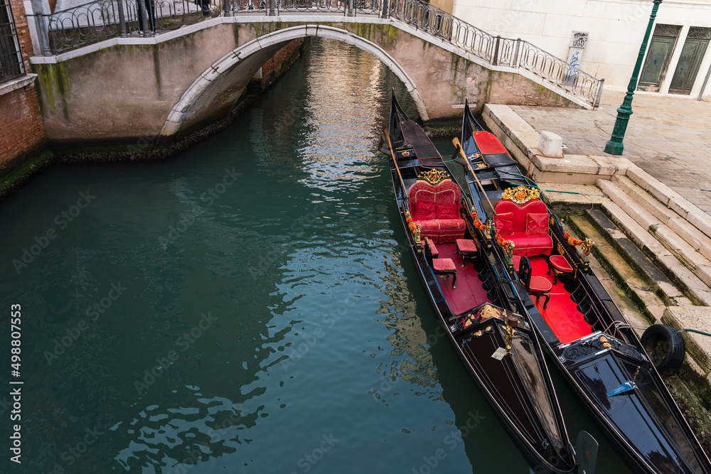 Close up of multiple empty gondolas parked by a canal in Venice, Italy 