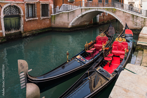 Close up of multiple empty gondolas parked by a canal in Venice, Italy 