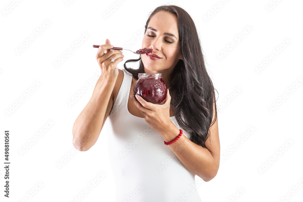 Charming brunette is holding a spoon sull of jam and smelling the tasty and sweet aroma. Isolated background Charming brunette is holding a spoon sull of jam and smelling the tasty and sweet aroma. Isolated background