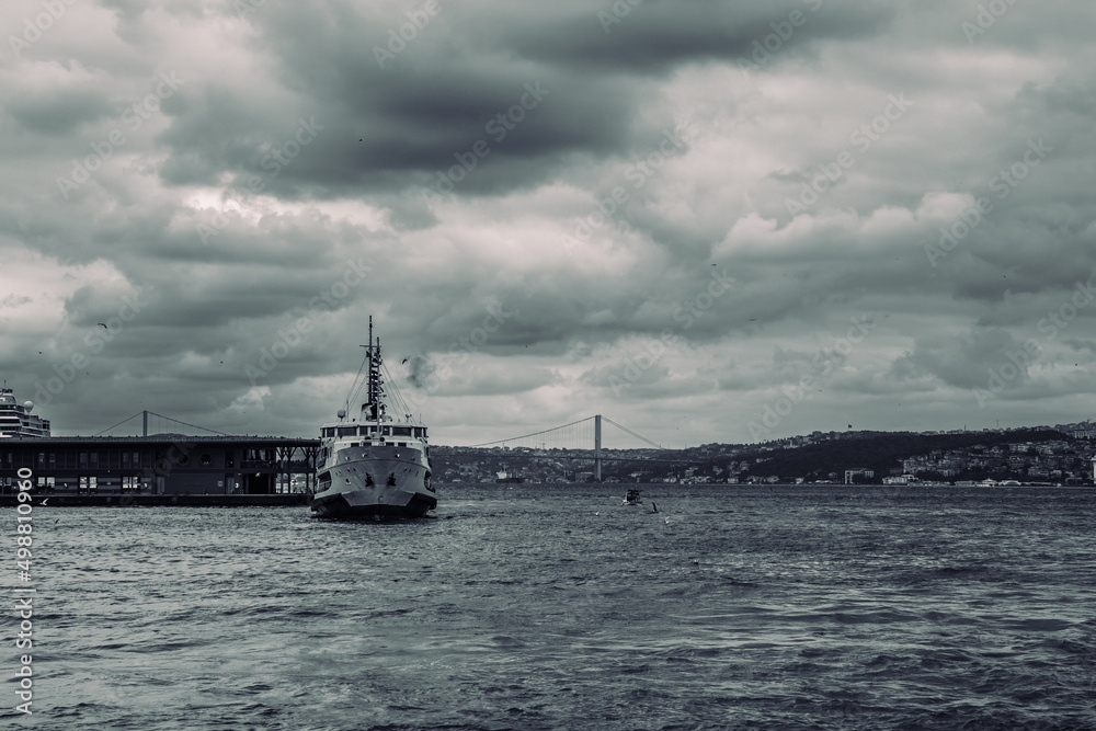 Moody Istanbul view. A ferry near the Karakoy Pier and Bosphorus Bridge