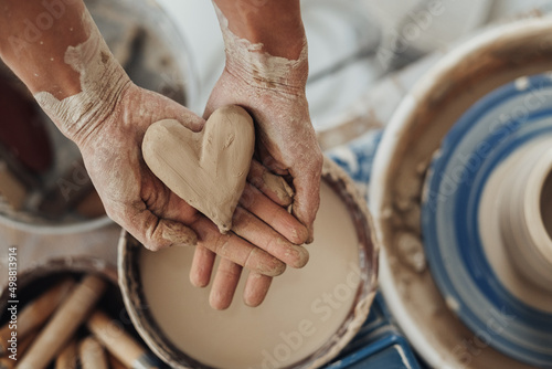 Flat Lay of Pottery Master Holding a Heart Crafted from Clay, Handmade Work photo