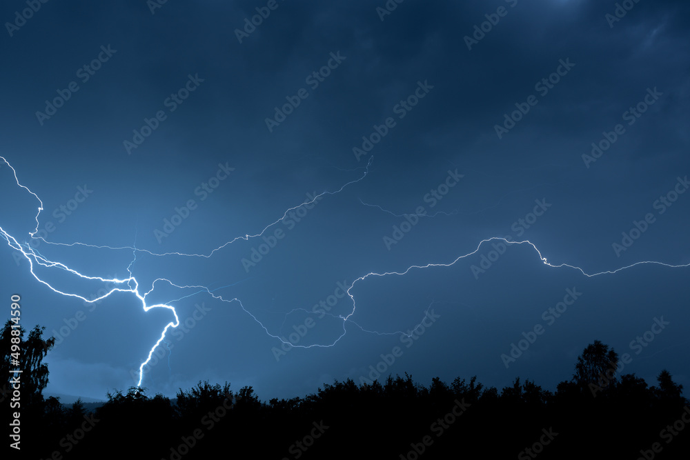 Electrical discharges during a summer storm, branched lightning bolts in the night sky. Electrical discharges during a summer storm, branched lightning bolts in the night sky.