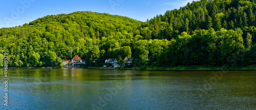 Fototapeta Naklejka Na Ścianę i Meble -  Lake Bystrzyckie located in a mountain valley, green forest on the slopes of the mountains, the view from the lake shore on a sunny summer day.