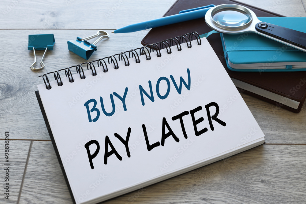Buy Now Pay Later open notepad near blue clips and blue notepad Buy Now Pay Later open notepad near blue clips and blue notepad