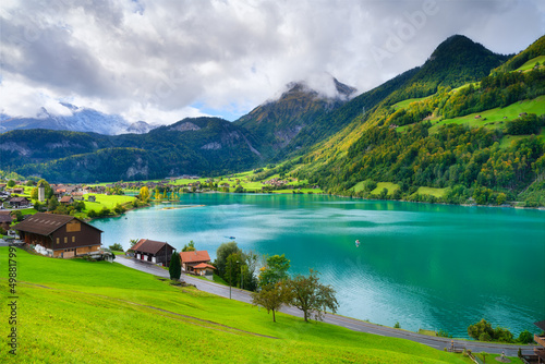 Lungern, canton of Obwalden, Switzerland. A view of rural homes in a green meadow. A lake in a mountain valley. A popular place to travel. photo