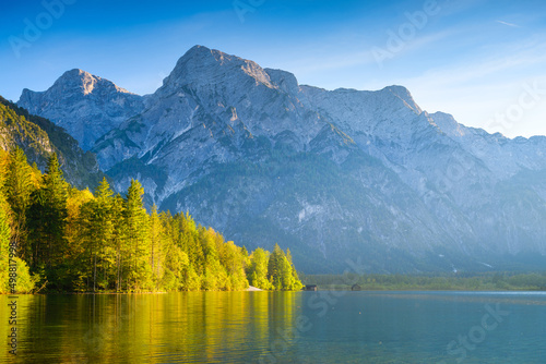 High mountains and reflection on the surface of the lake. The forest near the...