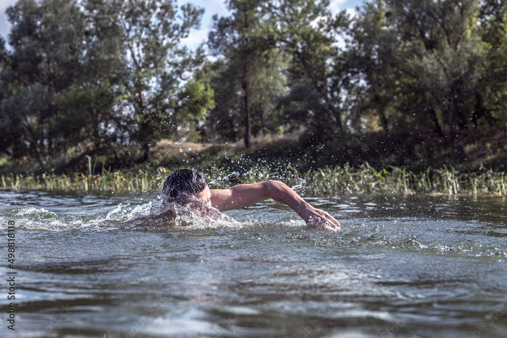 The young man swimming in the river