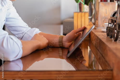 Hands of unknown man using a tablet in an elegant and quiet place. Concept of young businessman.