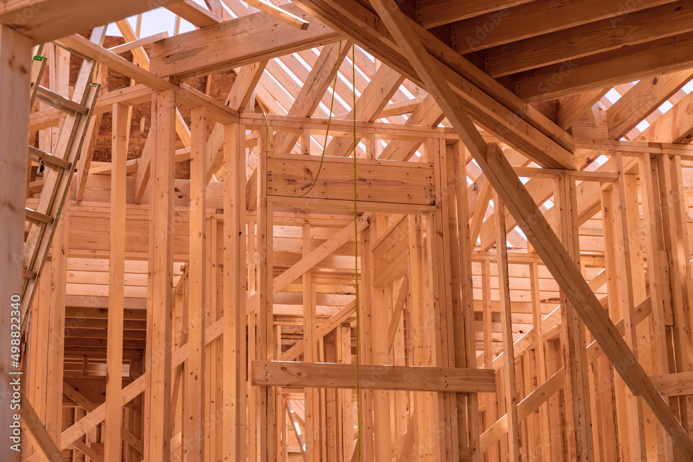New house construction with wooden beams the ceiling and wall system built frame New house construction with wooden beams the ceiling and wall system built frame