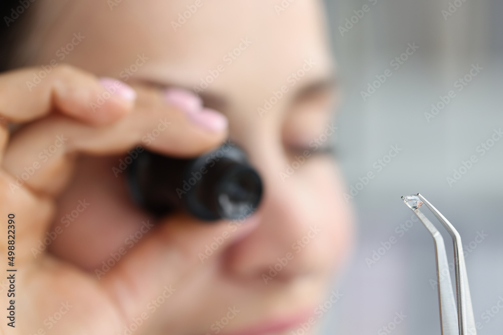 Jeweller examine polished diamond through magnifying glass, diamond jewellery under grading - obrazy, fototapety, plakaty 