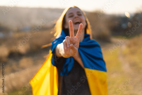 Cheerful ukrainian girl that shows a sign of peace or victory. Independence Day. Flag Day. Constitution day. photo