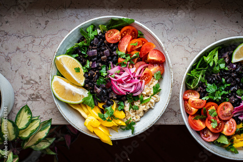 Two salad Burrito Bowls on a bar
