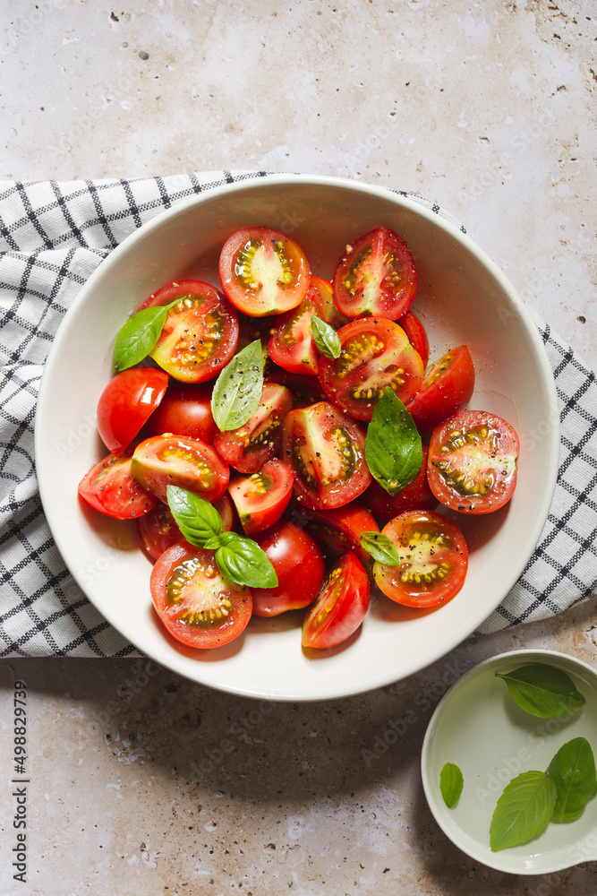 Cherry tomatoes with basil leaves in a bowl Cherry tomatoes with basil leaves in a bowl