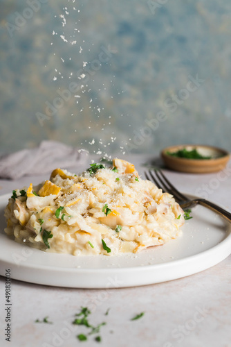 A small plate of smoked haddock risotto with a sprinke of parmesan falling down photo