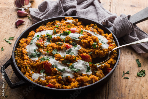 Red lentil dahl topped with yogurt photo