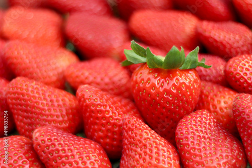 Strawberry, background Large grain and sweet. This strawberry is produced in Huelva, Spain. Just one showing the green crown