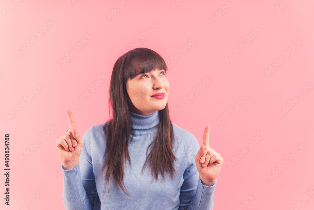 Pretty young woman points and looks above, studio shot pink background isolated copy space ads and promotion concept . High quality photo Pretty young woman points and looks above, studio shot pink background isolated copy space ads and promotion concept . High quality photo