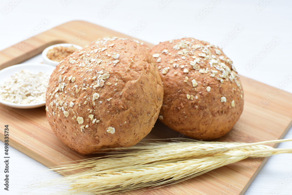 Round wholemeal oat bread, sweetened with natural panela, displayed on white wood