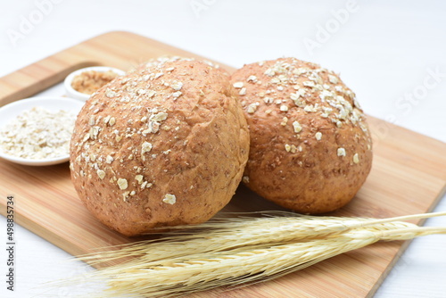 Round wholemeal oat bread, sweetened with natural panela, displayed on white wood