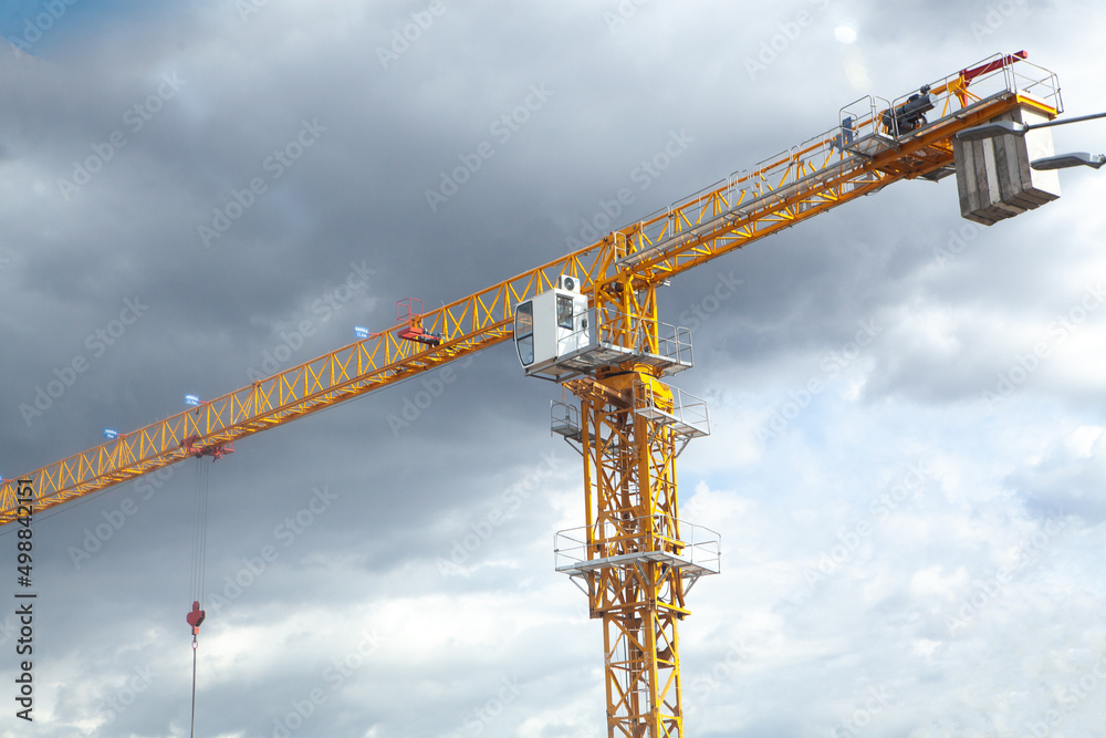 Yellow construction jib crane tower against blue sky Yellow construction jib crane tower against blue sky