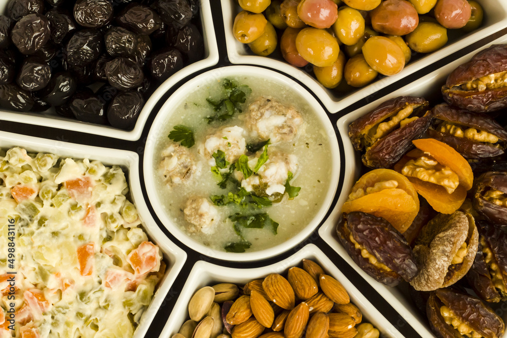 Traditional Ramadan iftar,beginning menu set background with soup,olives,date fruit,nuts and salad.Top view