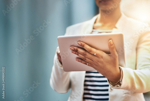 Wherever she goes, success simply tags along. Closeup shot of an unrecognizable businesswoman using a digital tablet in the city.