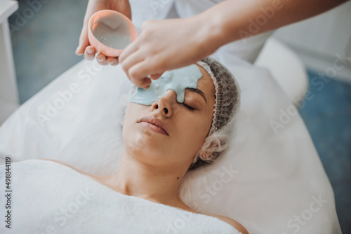 Woman makes an alginate mask therapy at spa salon. Medical treatment. Skin care. Doctor hand. photo