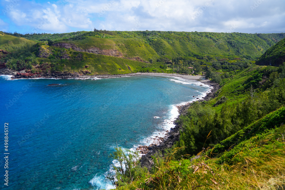 Fototapeta premium Honokohau Bay between the Kahekili and Honoapiilani highways on West Maui, Hawaii - Lush valley ending on a gravel beach in the Pacific Ocean