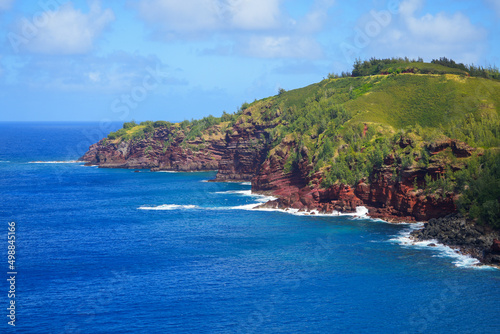 Red cliffs in Honokohau Bay between the Kahekili and Honoapiilani highways on West Maui, Hawaii - Lush valley ending on a gravel beach in the Pacific Ocean