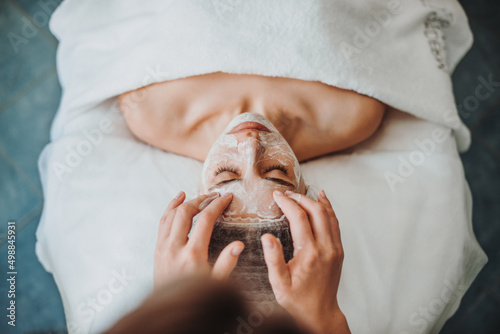 Canvas Print Woman getting facial care by beautician's hands at spa salon